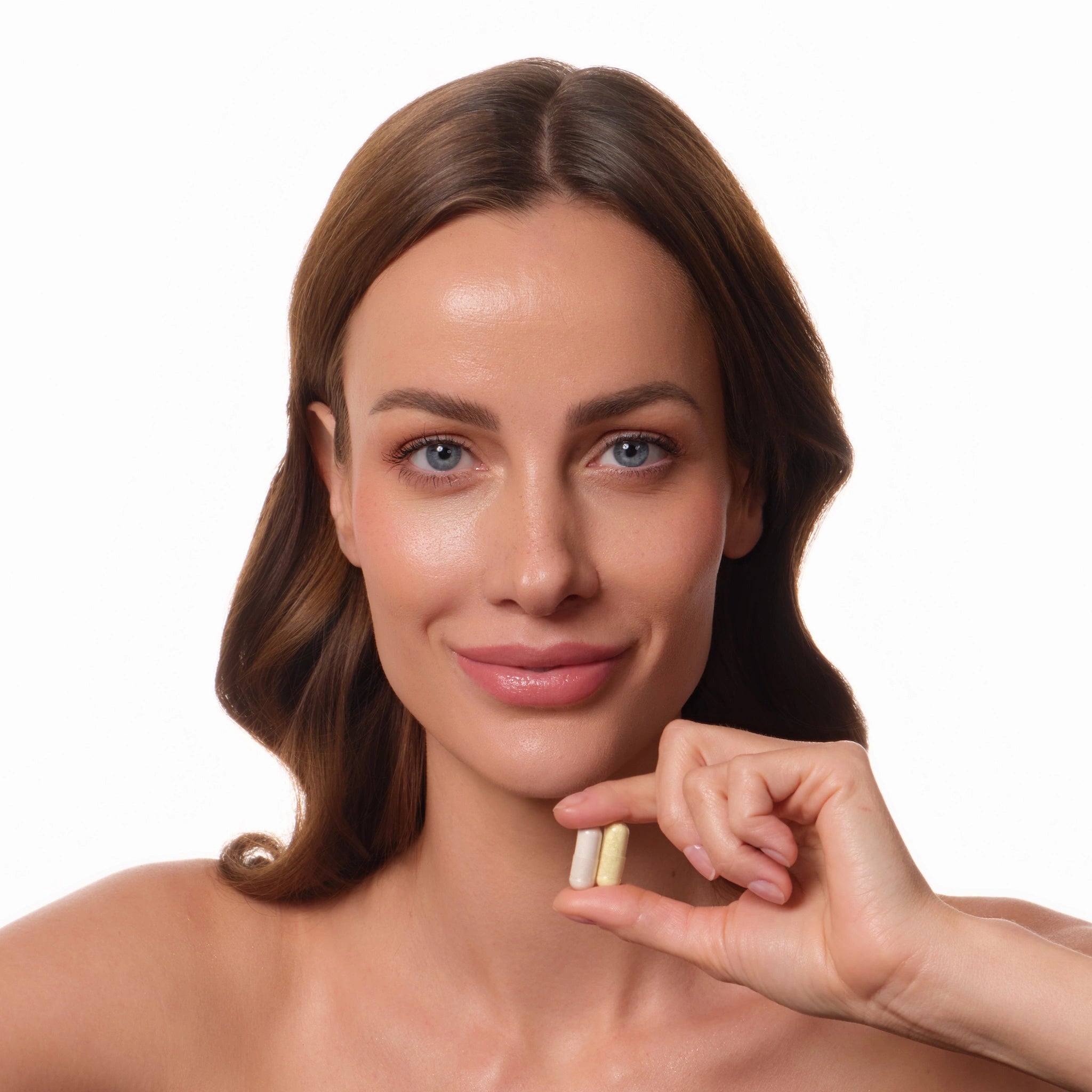Frau mit Longevity-Bundle Kapseln in der Hand – vorbereitet auf die tägliche Routine.